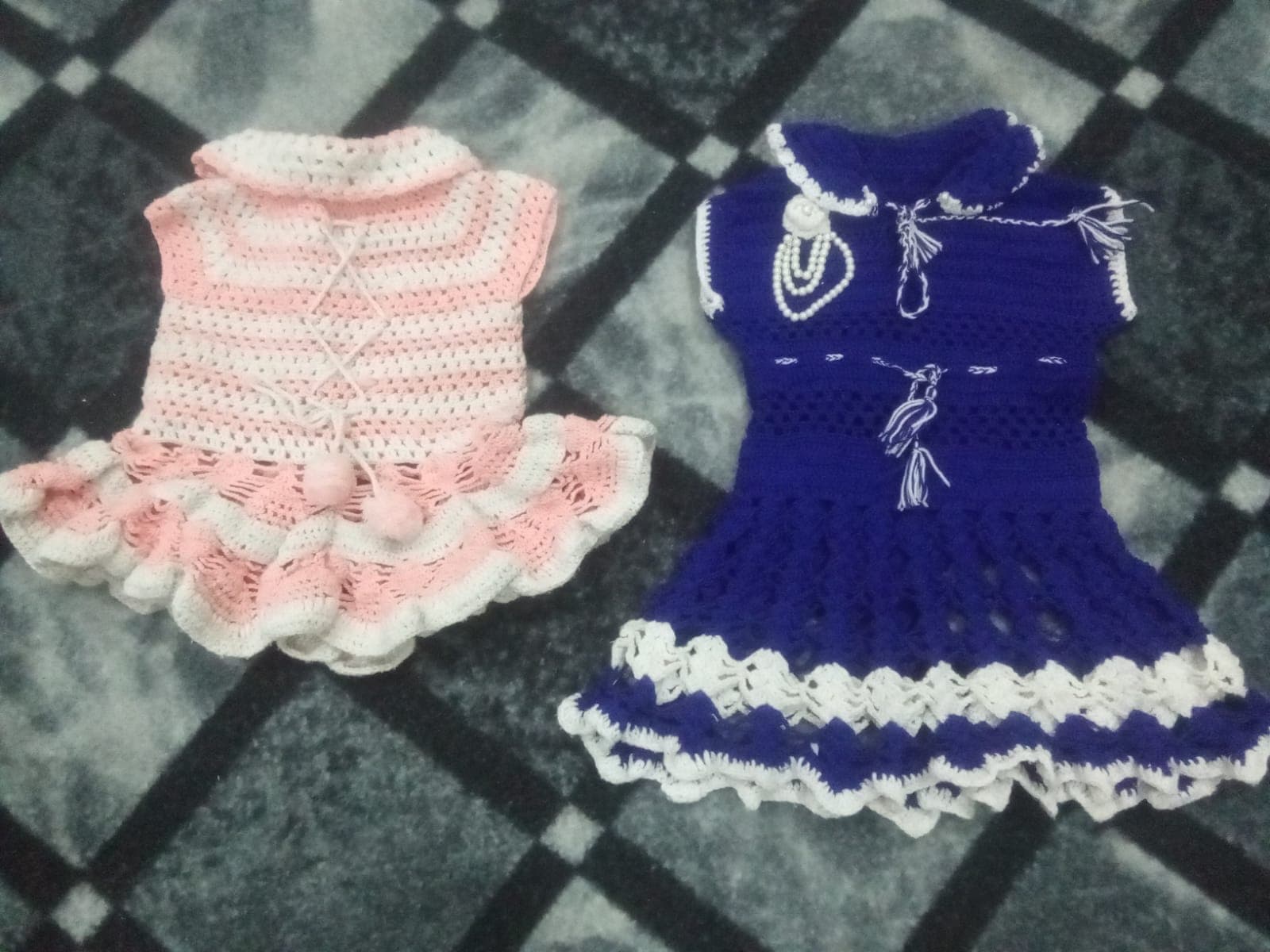 Hand-crocheted pink and purple dresses made by trainees